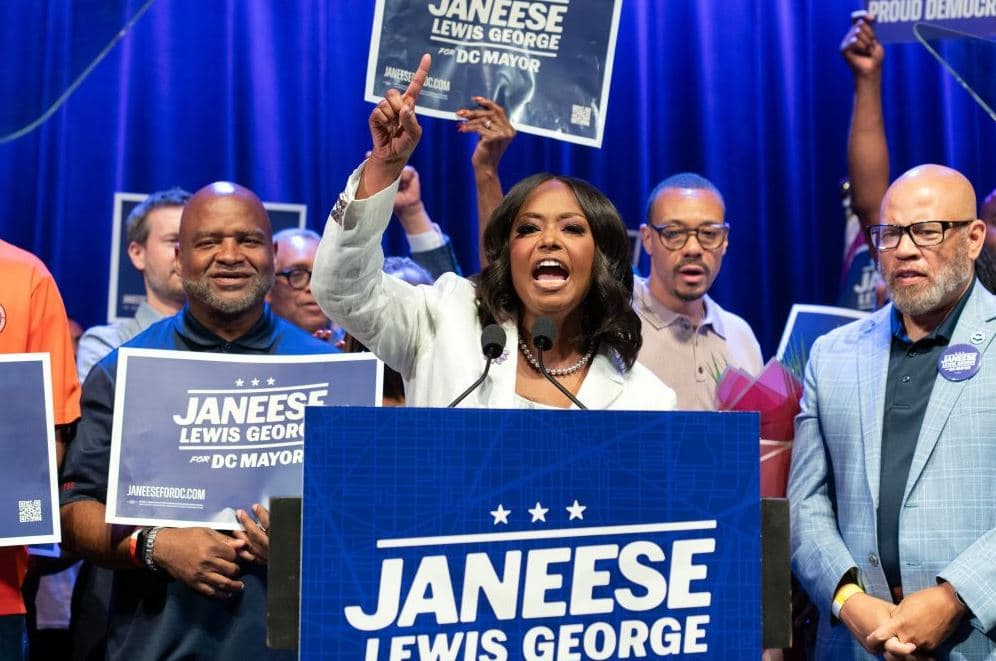 Janeese Lewis George speaking at a campaign rally for D.C. mayor with supporters holding signs.